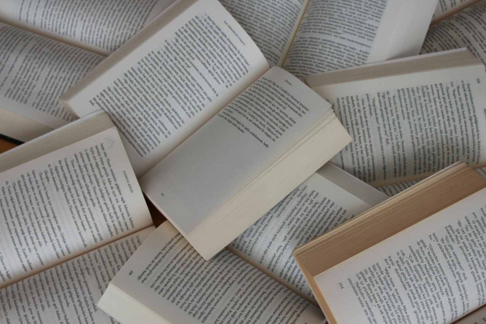 Diversos llibres oberts escampats, amb les pàgines de text a la vista.